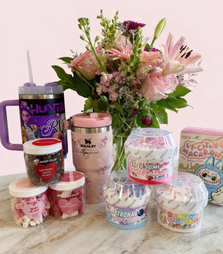 An assortment of gifts including as labubu, custom stanley bottles, candy, and slime.