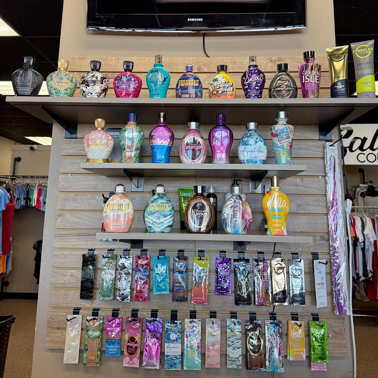 Ultra Tan at First Impressions display shelves filled with professional tanning lotion bottles and sample packets.